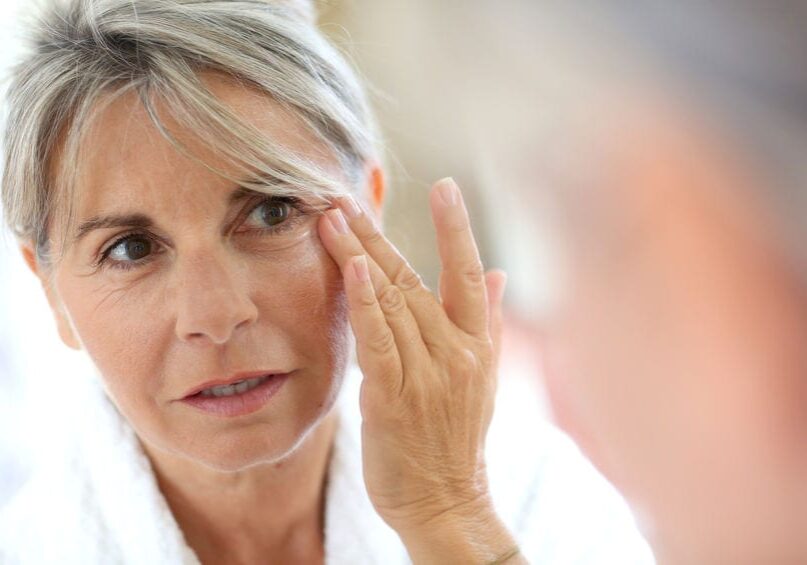 Senior woman applying anti-wrinkles cream